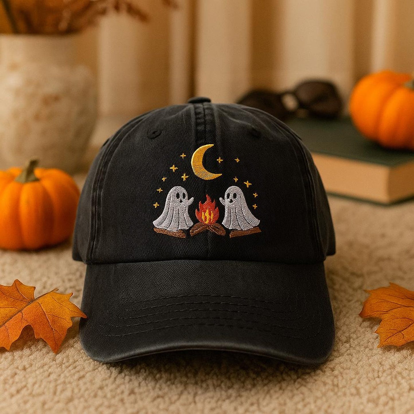 Black embroidered hat featuring two ghosts around a campfire under a moon and stars – perfect for Halloween and fall style