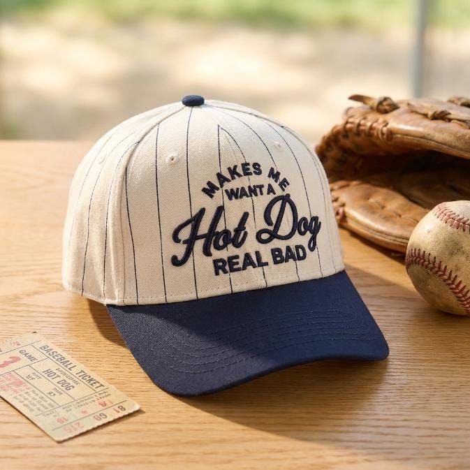 Embroidered pinstripe hot dog hat displayed beside a baseball glove and baseball