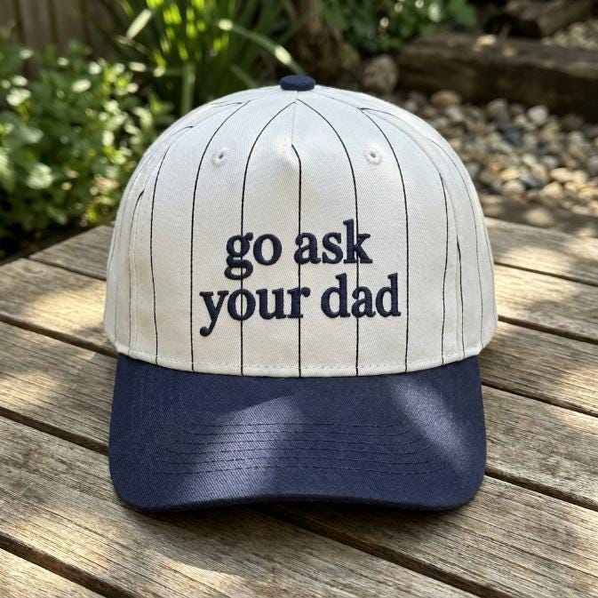 Front view of white pinstripe Go Ask Your Dad baseball cap with navy brim