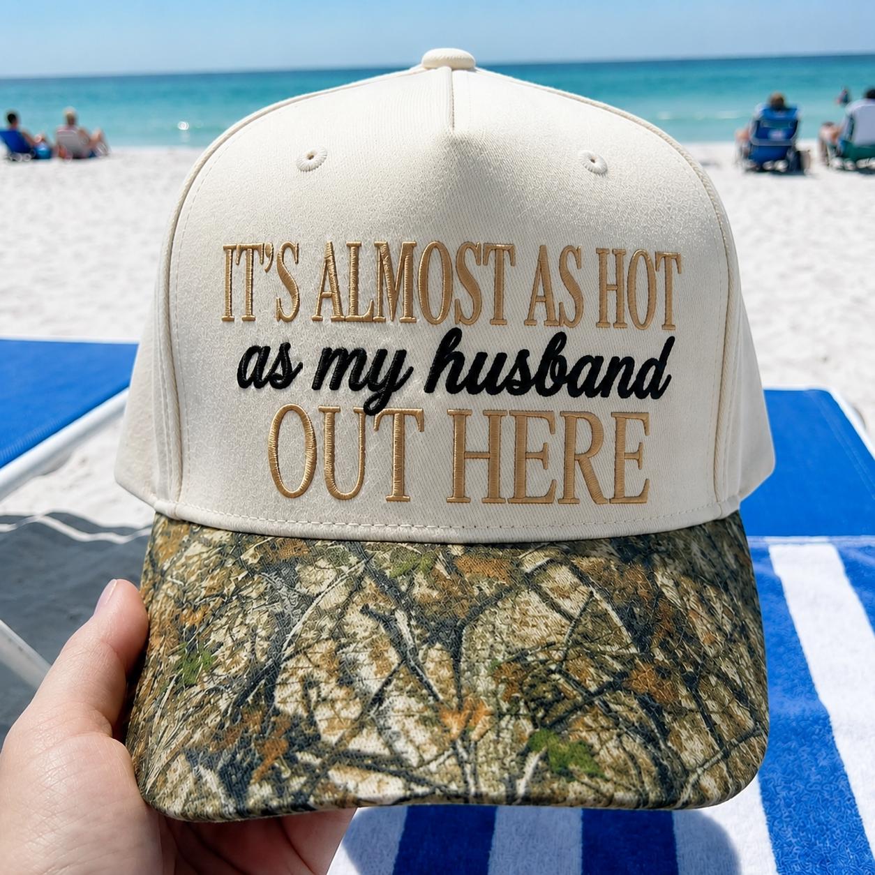 Funny embroidered hat with “It's Almost as Hot as My Husband Out Here” text and camouflage-patterned bill