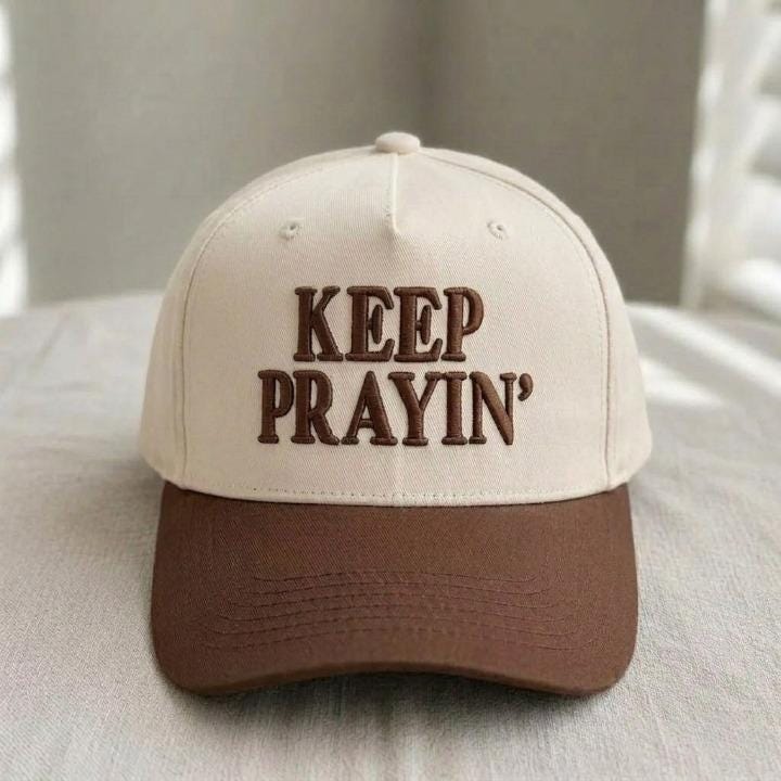 Cream and brown Keep Prayin’ faith hat shown from the front