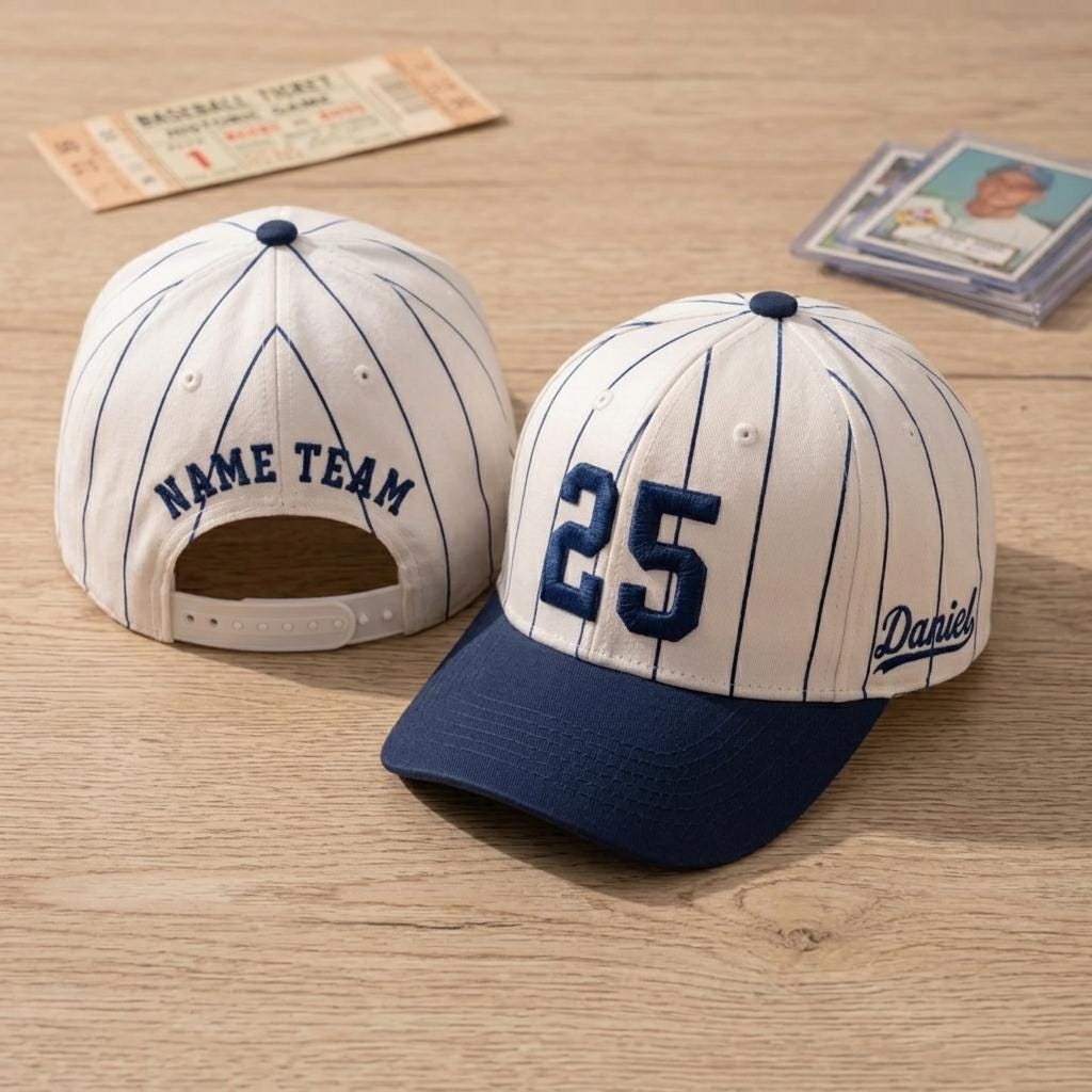 Cream and navy pinstripe baseball hat displayed on a wood surface with embroidered 25 and Daniel side script