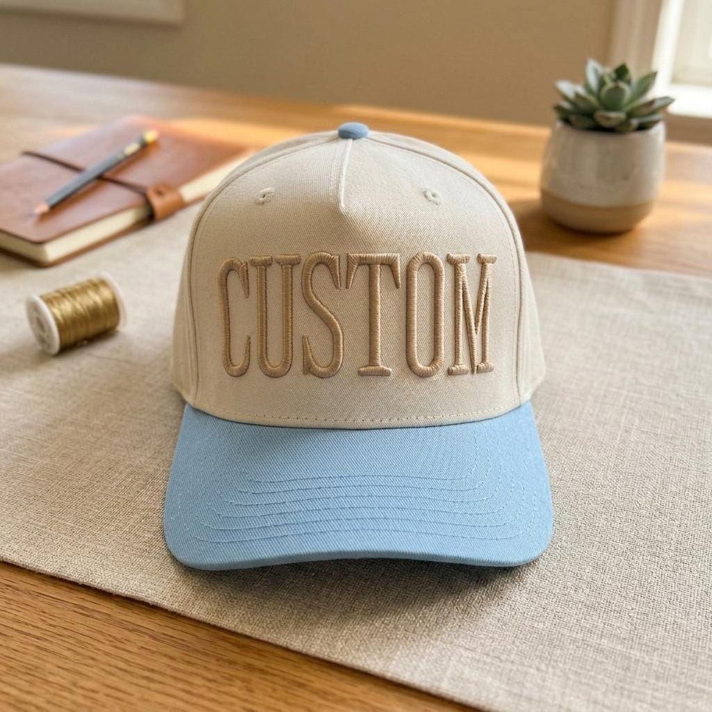 Cream hat with embroidered CUSTOM lettering and light blue brim
