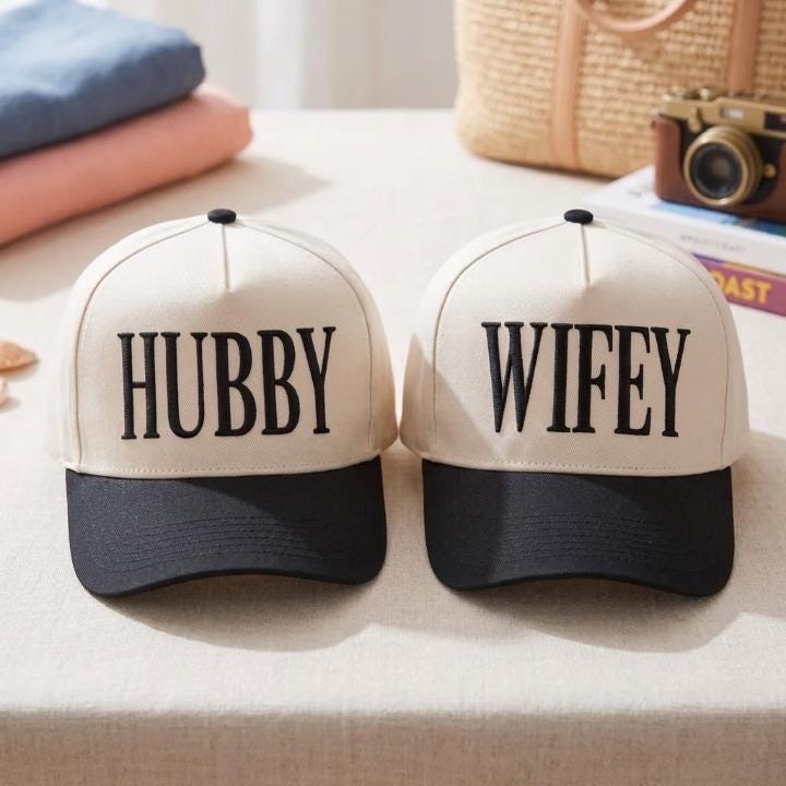 Matching black and cream Hubby Wifey caps displayed indoors