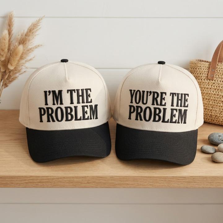 Two coordinated statement hats displayed side by side on a wooden shelf