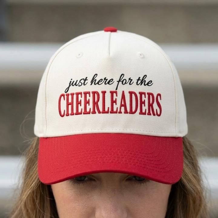 Cheerleading supporter wearing cream and red embroidered trucker cap