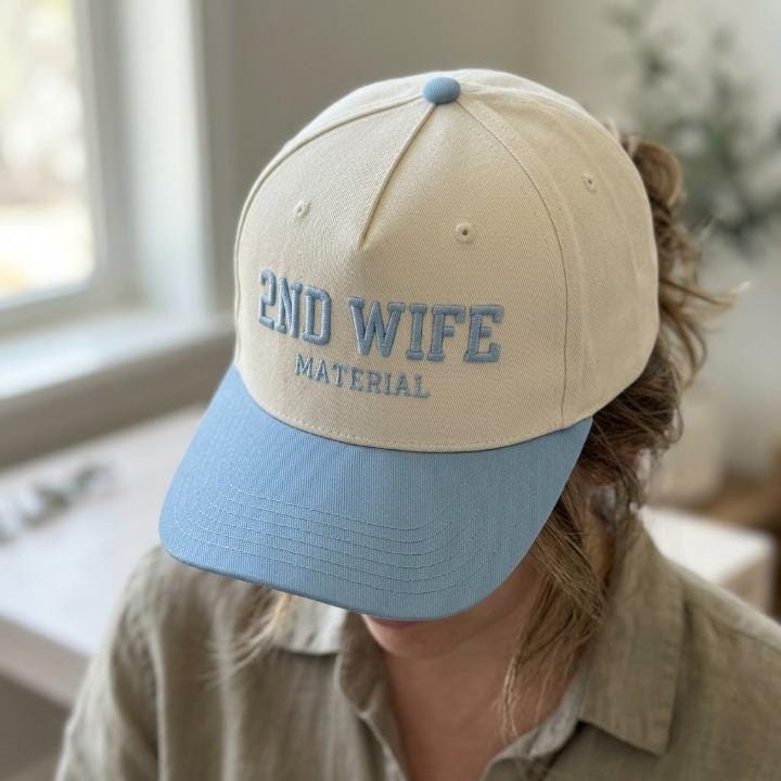 Person wearing a cream and light blue 2ND WIFE MATERIAL hat