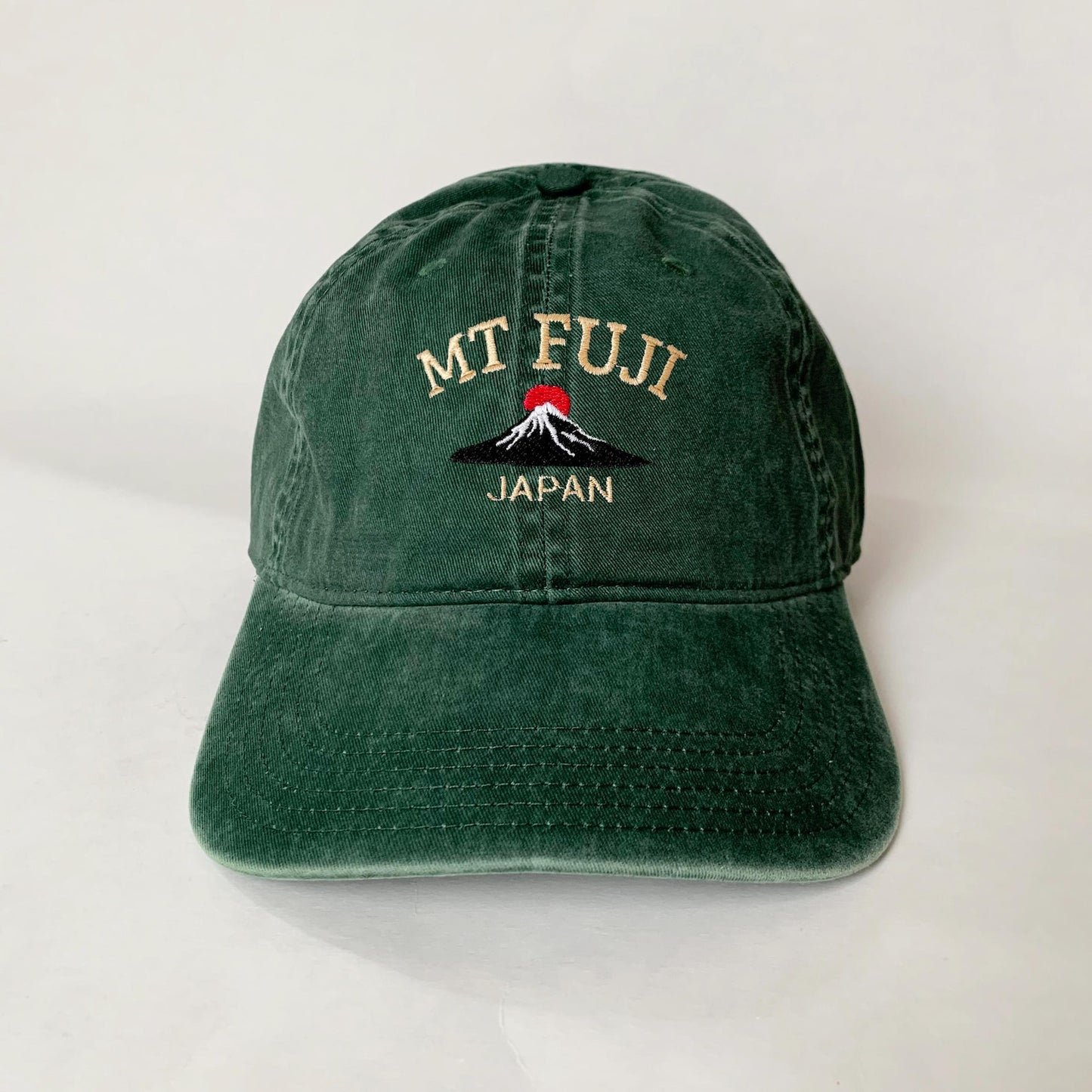 Green washed dad hat with embroidered Mt. Fuji and red sun design