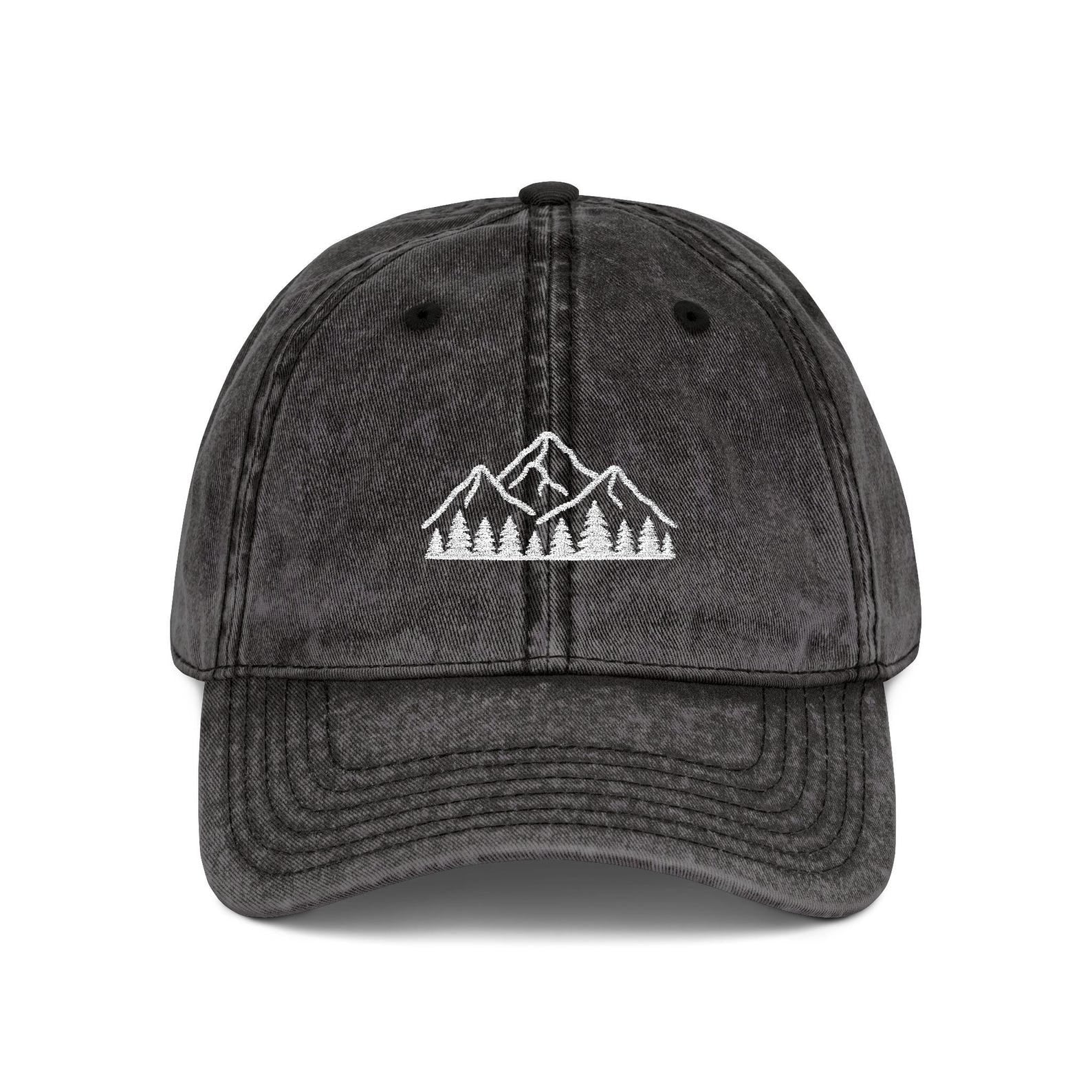 Black washed dad hat embroidered with white mountain and forest design