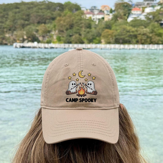 Beige embroidered hat with two ghosts roasting marshmallows over a fire and “Camp Spooky” text – perfect for Halloween and fall outfits