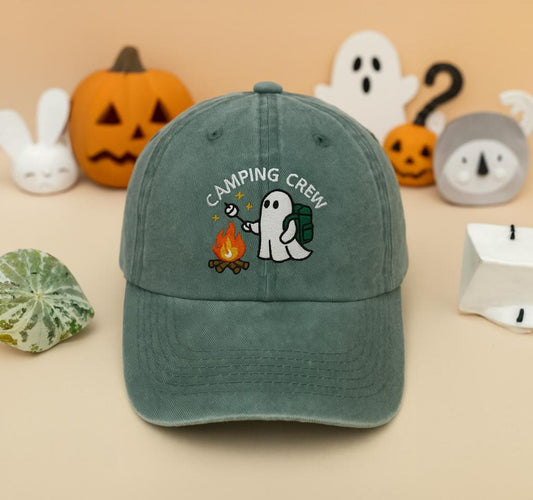 Forest green washed dad hat embroidered with ghost roasting marshmallows by a fire and “Camping Crew” text – spooky cute camping aesthetic