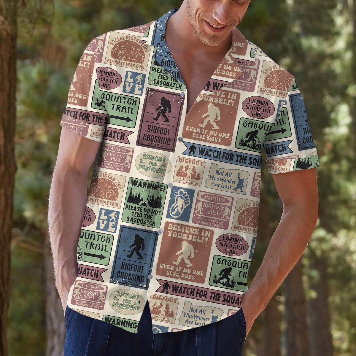 Model outdoors wearing the printed Bigfoot and wilderness sign Hawaiian shirt