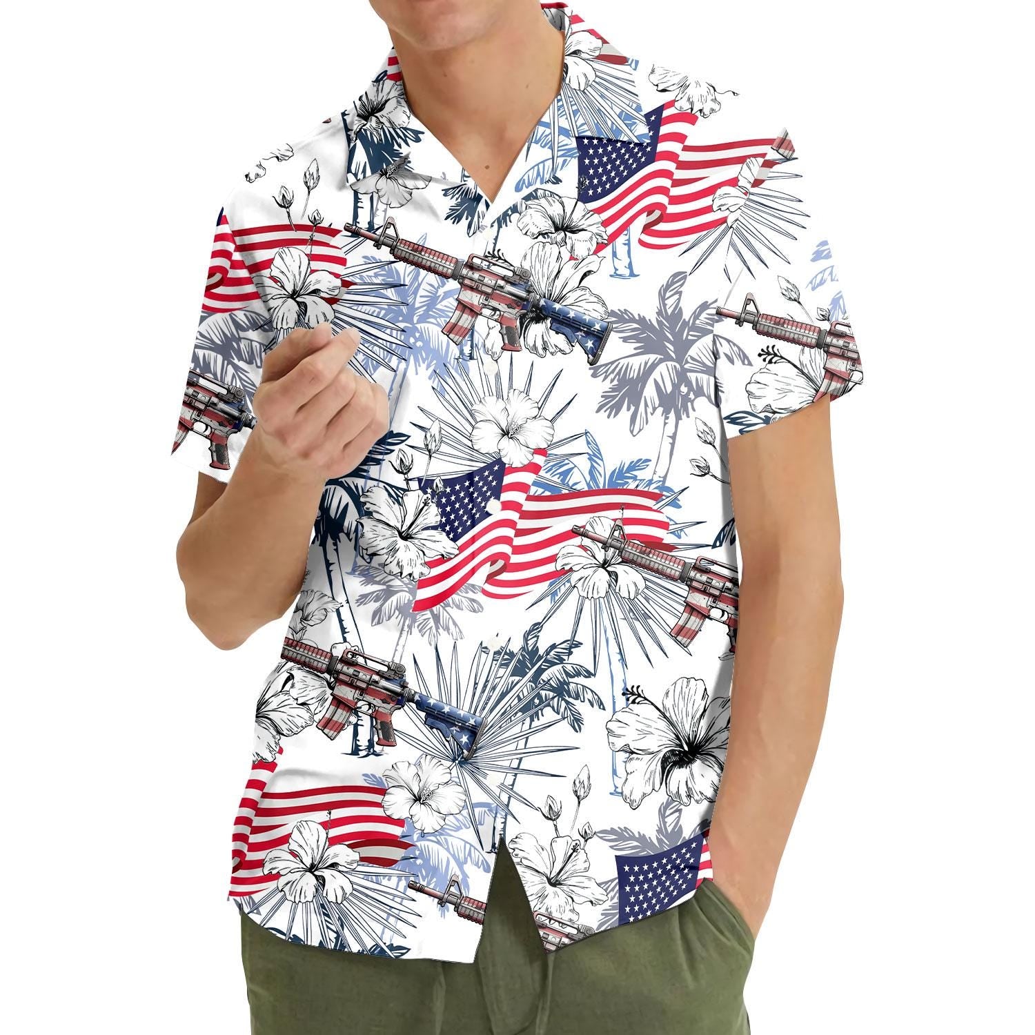 Model wearing patriotic Hawaiian shirt with American flags, hibiscus, and rifle motif