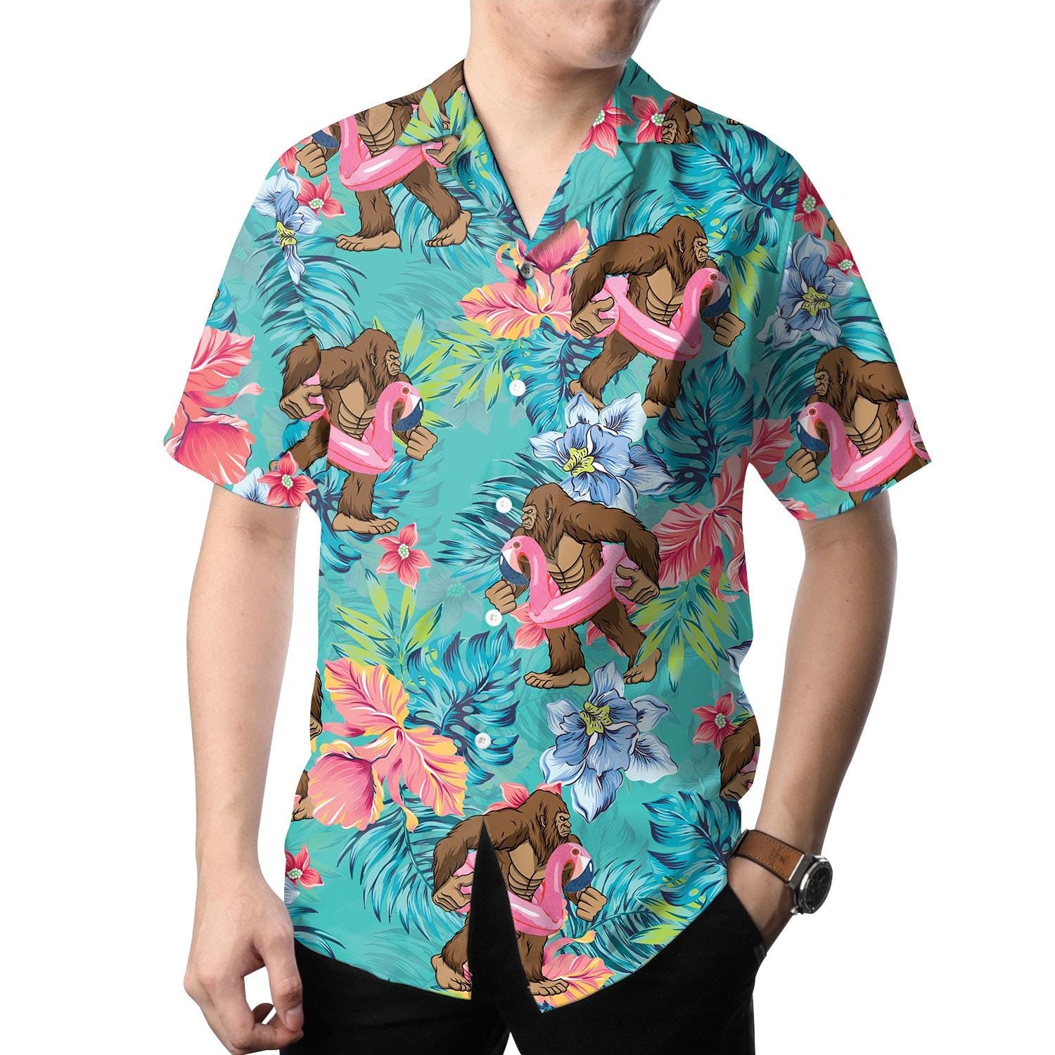 Model wearing the turquoise ape and pink flamingo Hawaiian shirt with tropical flowers
