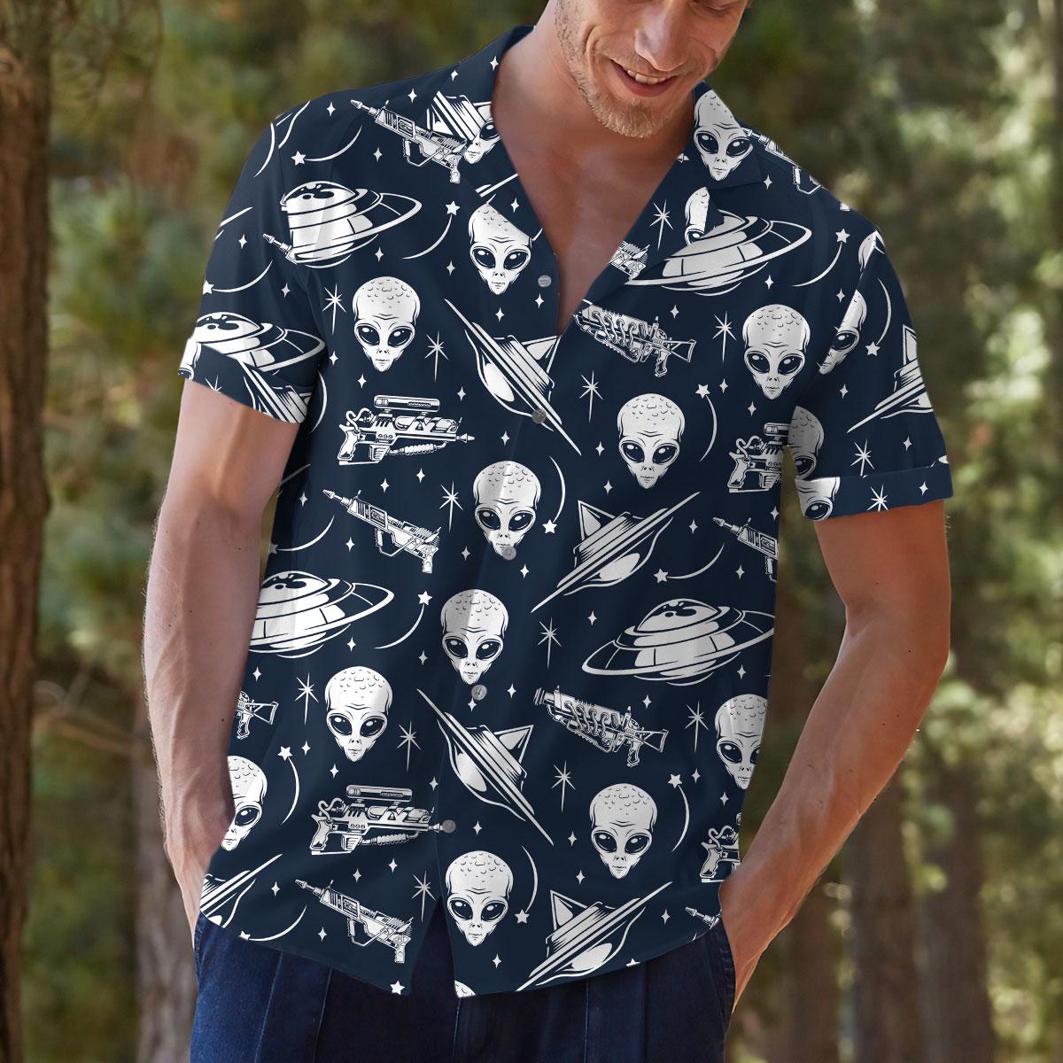 Model outdoors wearing a navy space print Hawaiian shirt with alien and UFO artwork