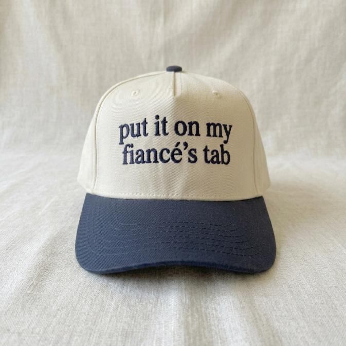 Angled view of two-tone trucker cap with playful relationship phrase