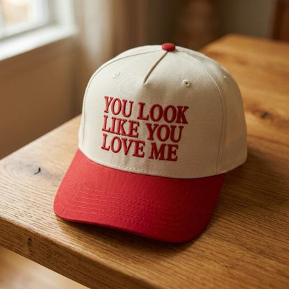 Two-tone cream and red cap with red love message embroidery on a wooden table