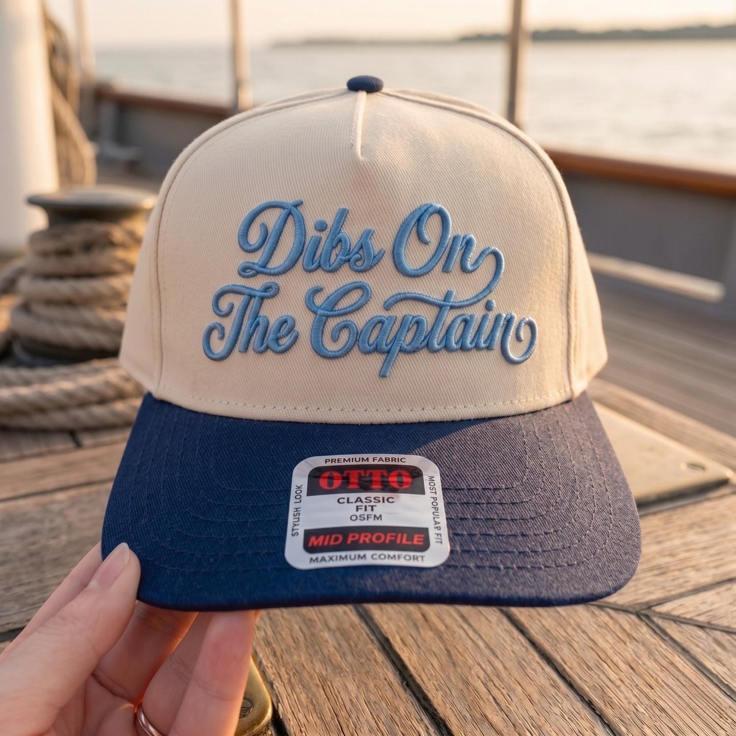 Dibs On The Captain hat with blue script embroidery and a navy brim