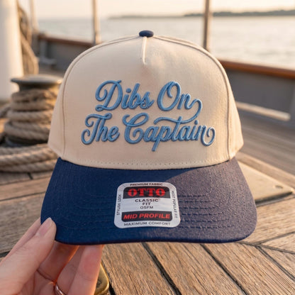 Dibs On The Captain hat with blue script embroidery and a navy brim