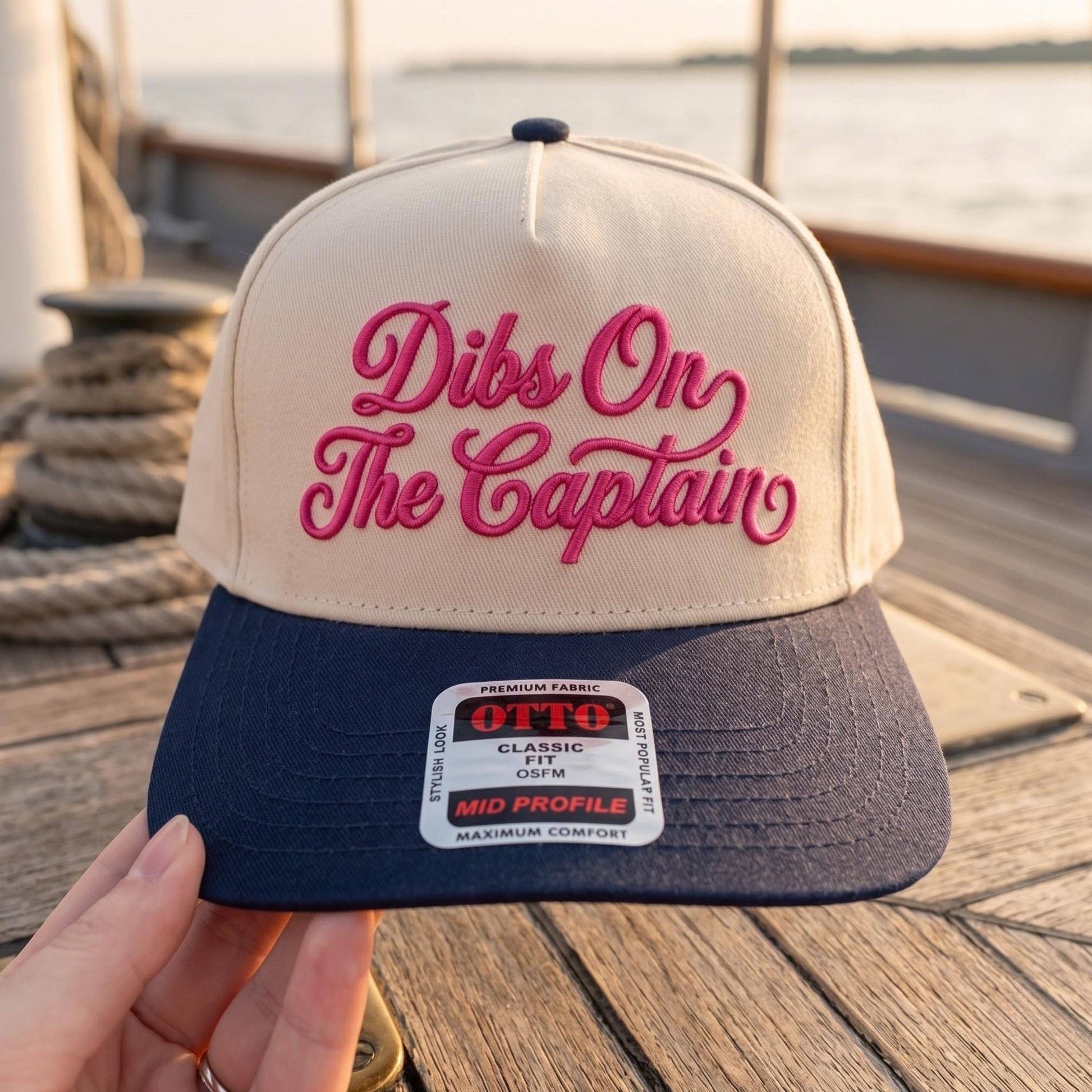Dibs On The Captain embroidered hat with pink script on a cream crown and navy brim