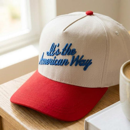 Embroidered American Way trucker hat resting beside a coffee cup