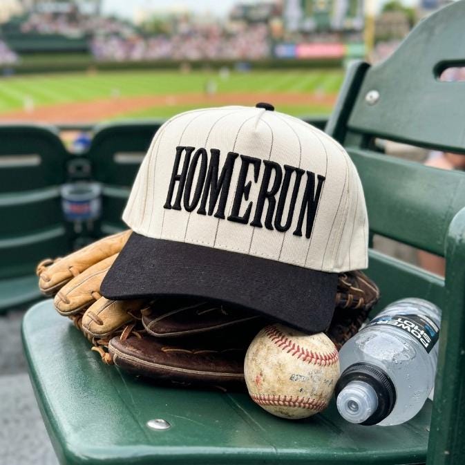 Homerun pinstripe hat displayed on a baseball glove and ball at a stadium