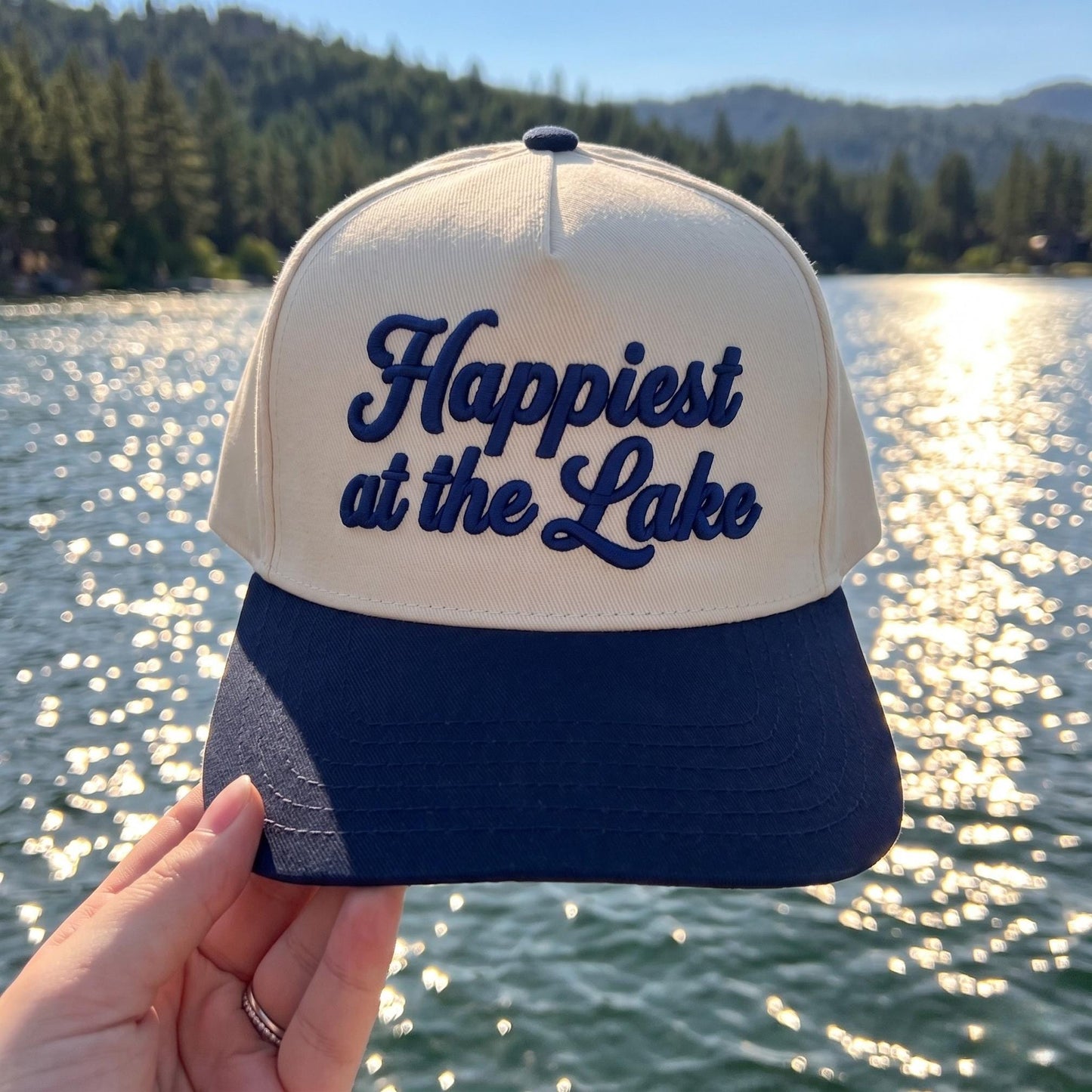 Cream and navy two-tone Happiest at the Lake embroidered hat by a scenic lake