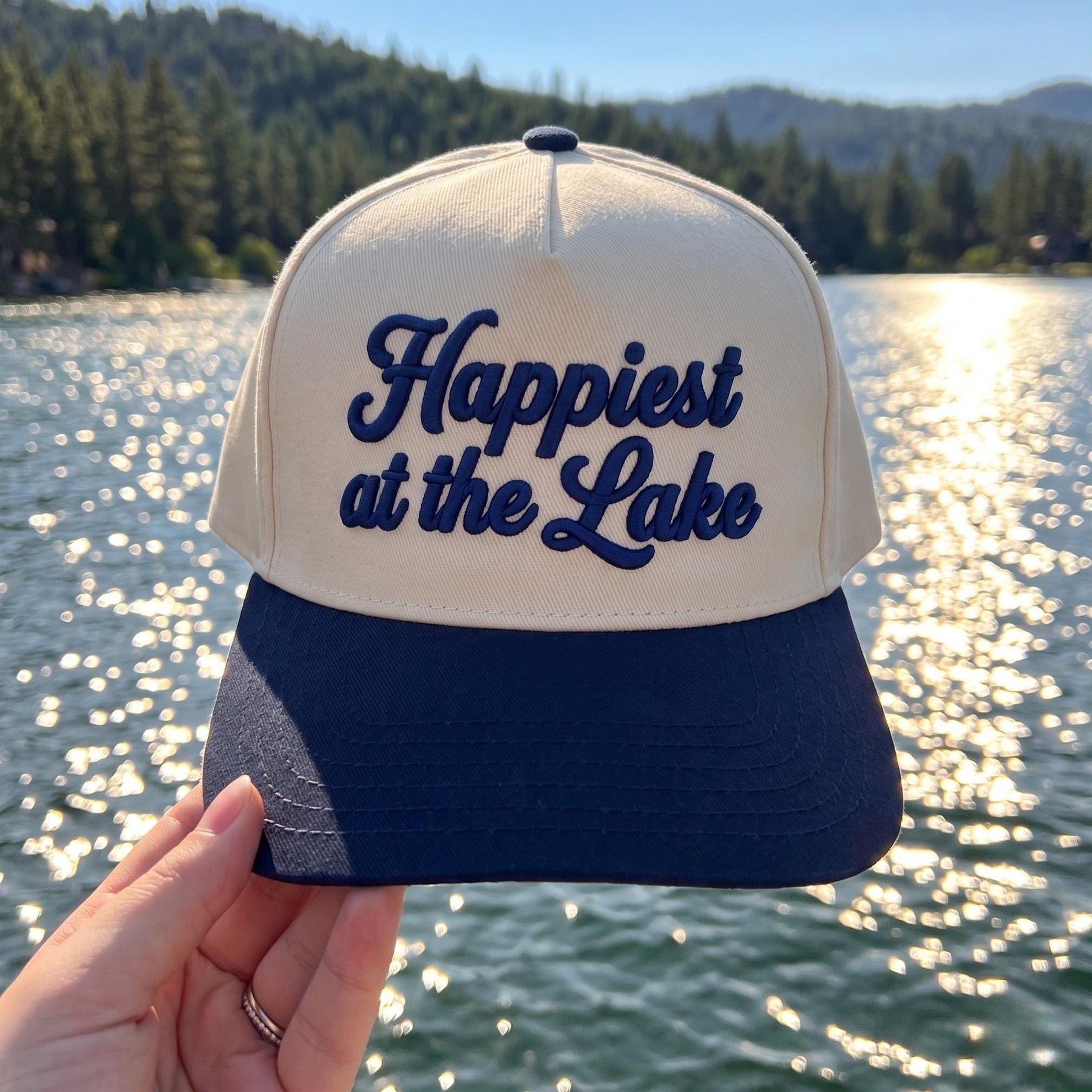 Cream and navy two-tone Happiest at the Lake embroidered hat by a scenic lake