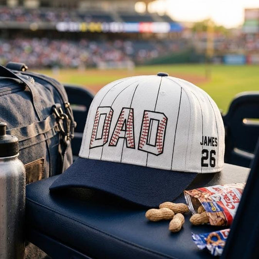 Pinstripe baseball hat with DAL lettering and James 26 side detail on a stadium seat