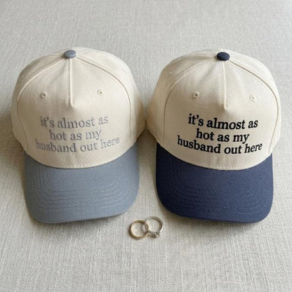 Close view of cream and navy trucker hat with funny husband-themed embroidery