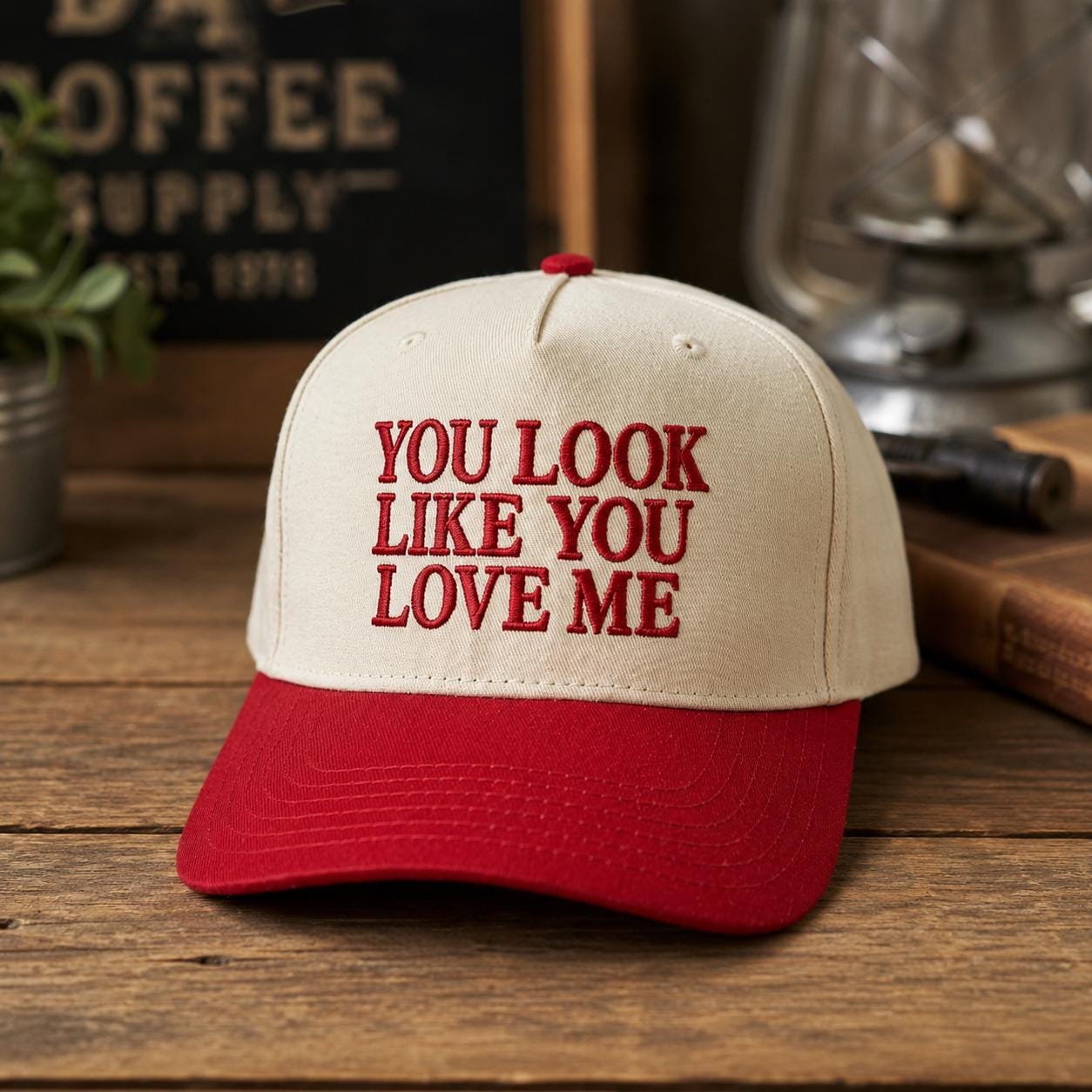 Cream and red two-tone trucker cap with embroidered “You Look Like You Love Me” text