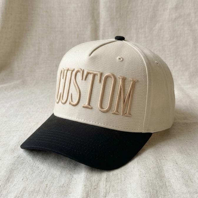 Angled view of the custom embroidered trucker hat showing the black curved bill