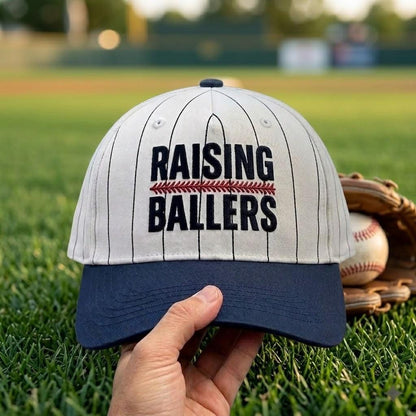 Raising Ballers pinstripe hat displayed on a baseball field with glove and ball