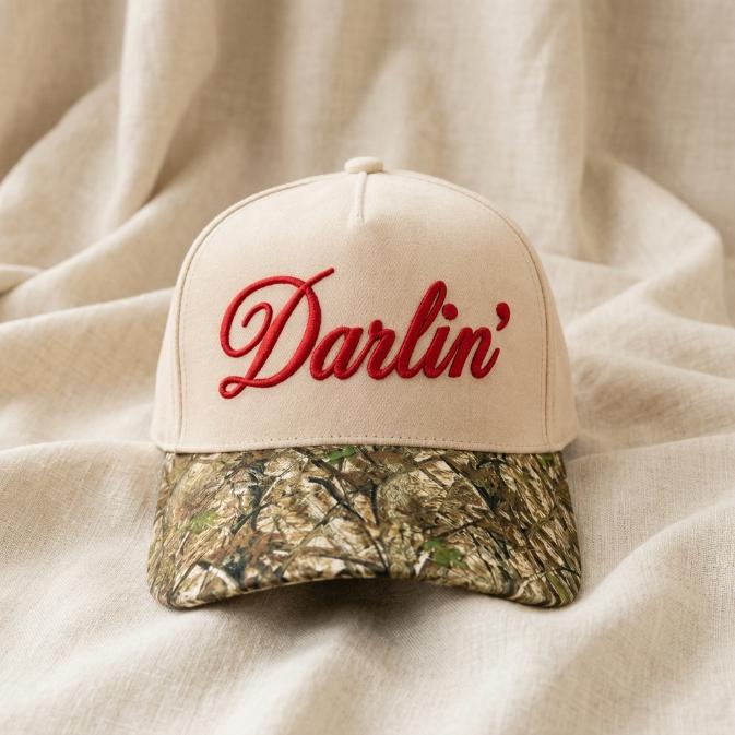 Cream Darlin' embroidered hat with red script and camouflage brim shown from the front
