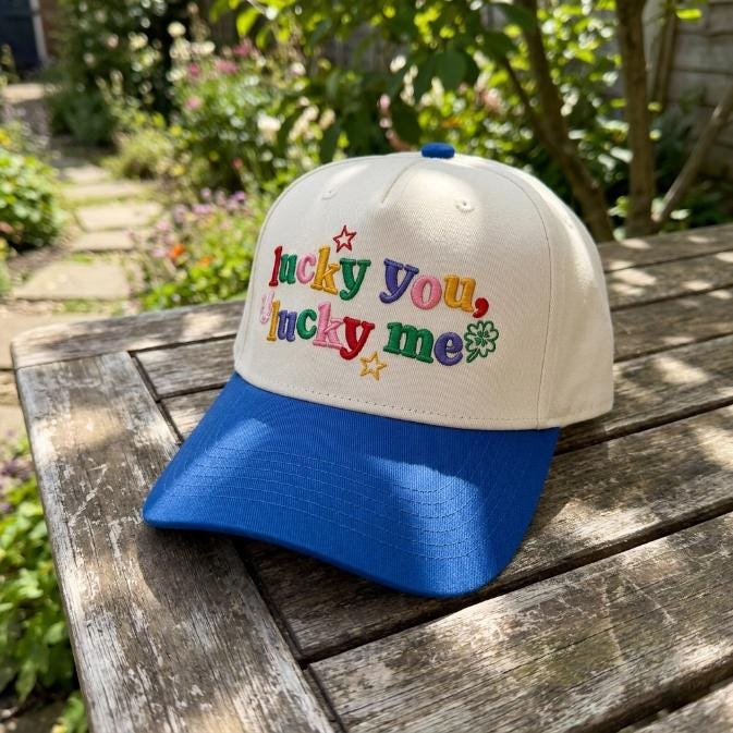 Angled view of the embroidered Lucky You Lucky Me two-tone hat with blue brim
