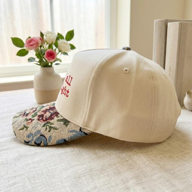 Side view of cream hat showing the floral brim and embroidered front design