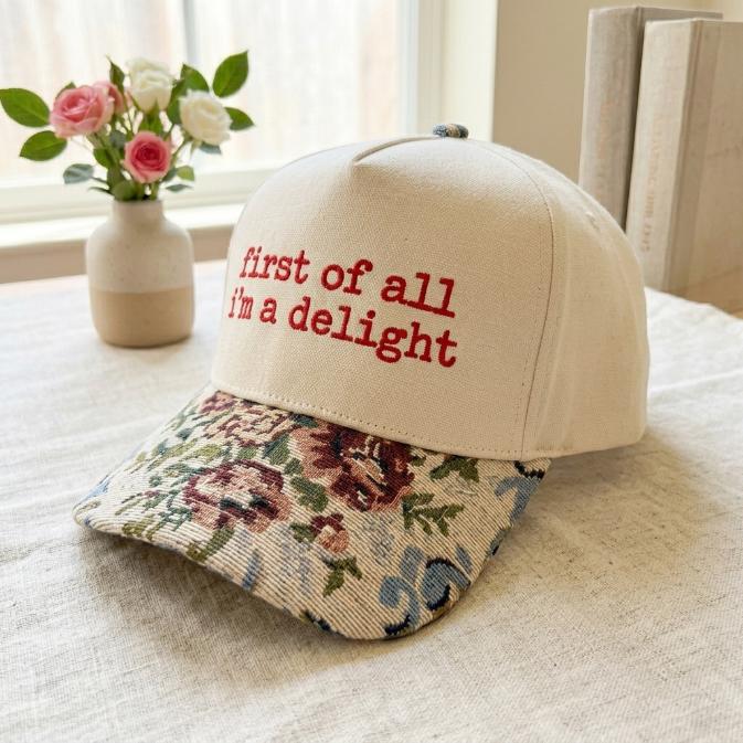 Angled view of embroidered floral brim hat with playful red lettering