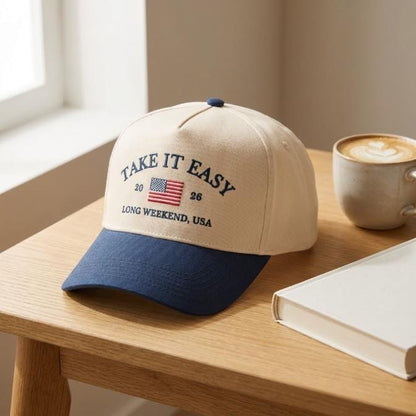 Side angle showing the cream crown and navy bill of the embroidered Take It Easy trucker hat