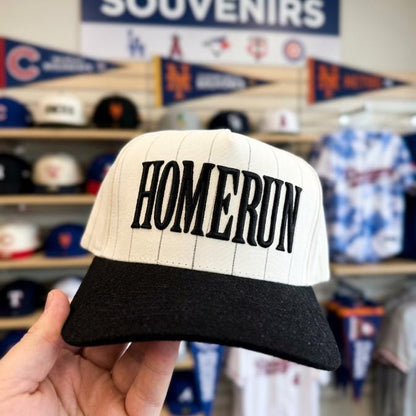 Front view of embroidered Homerun pinstripe hat in a baseball souvenir shop