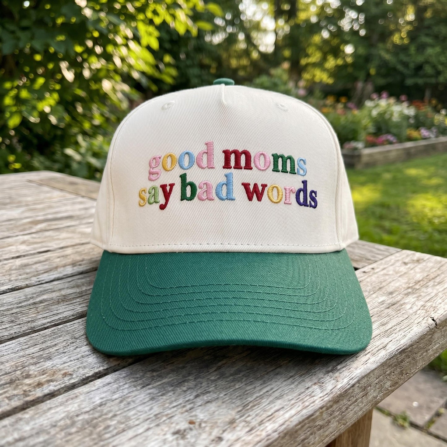 Embroidered mom trucker hat displayed outdoors on a wooden table
