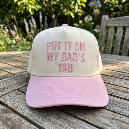 Front view of Put It On My Dad's Tab embroidered trucker hat outdoors