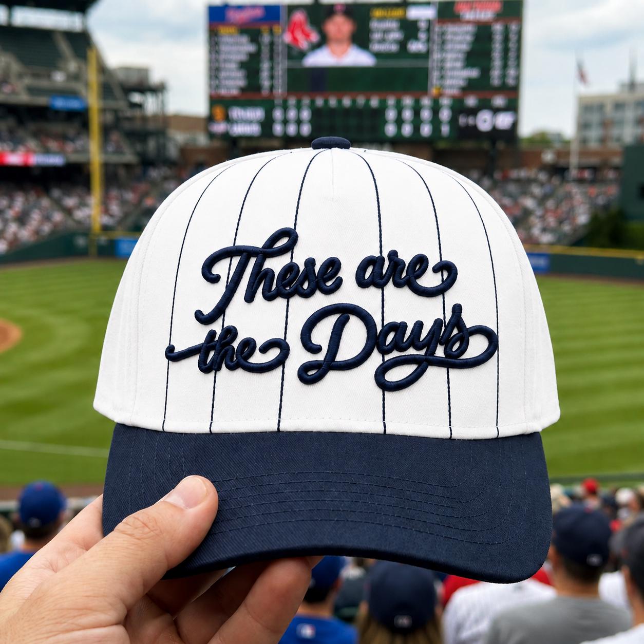 White and navy “These Are the Days” embroidered baseball hat shown at a baseball stadium