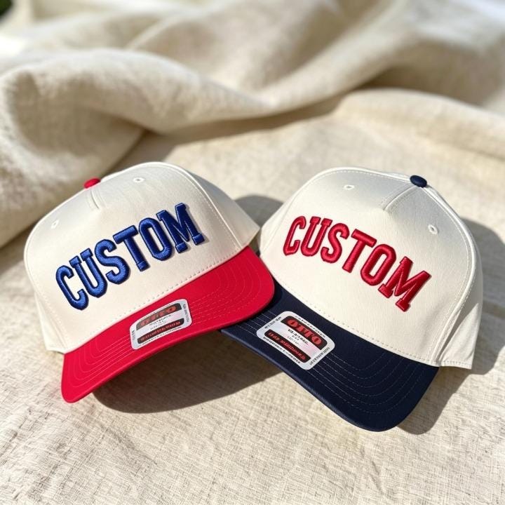Two custom embroidered two-tone trucker hats with blue and red lettering