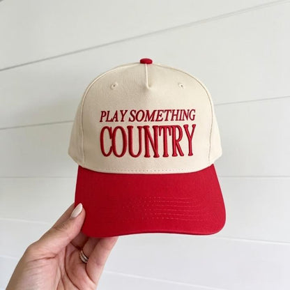 Two-tone country trucker hat with red brim and Play Something Country embroidery
