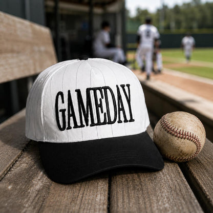 Game Day pinstripe hat displayed beside a baseball at a ballpark