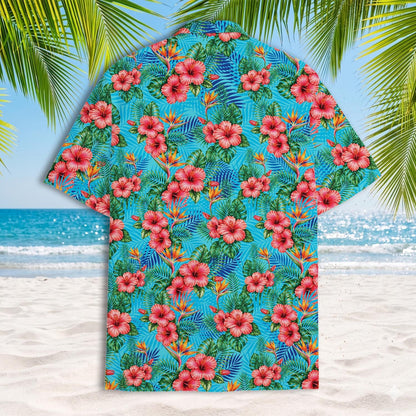 Back view of colorful turquoise Hawaiian shirt covered in pink flowers and tropical leaves