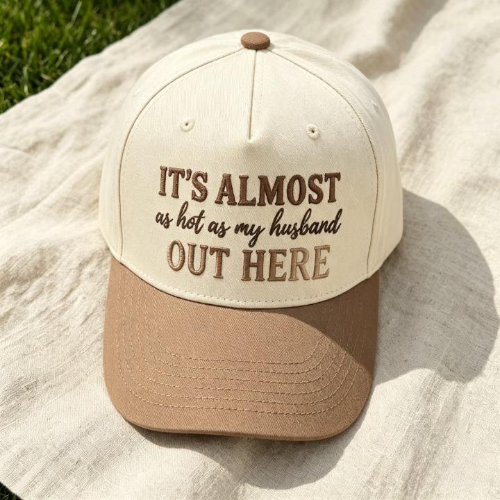 Close-up of funny embroidered quote hat reading It’s Almost as Hot as My Husband Out Here