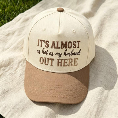 Close-up of funny embroidered quote hat reading It’s Almost as Hot as My Husband Out Here