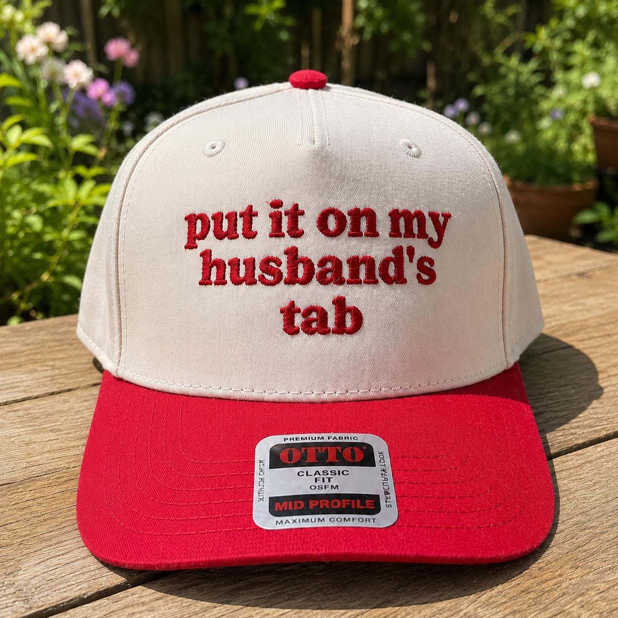 Front view of embroidered husband’s tab trucker hat outdoors