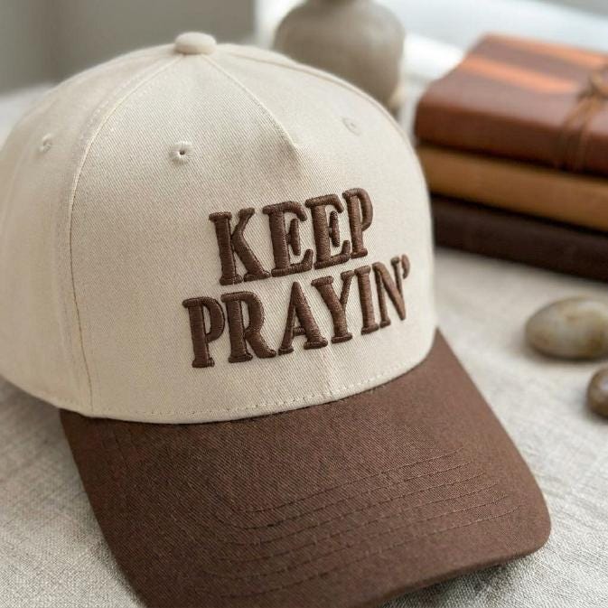 Angled view of two-tone Keep Prayin’ embroidered hat